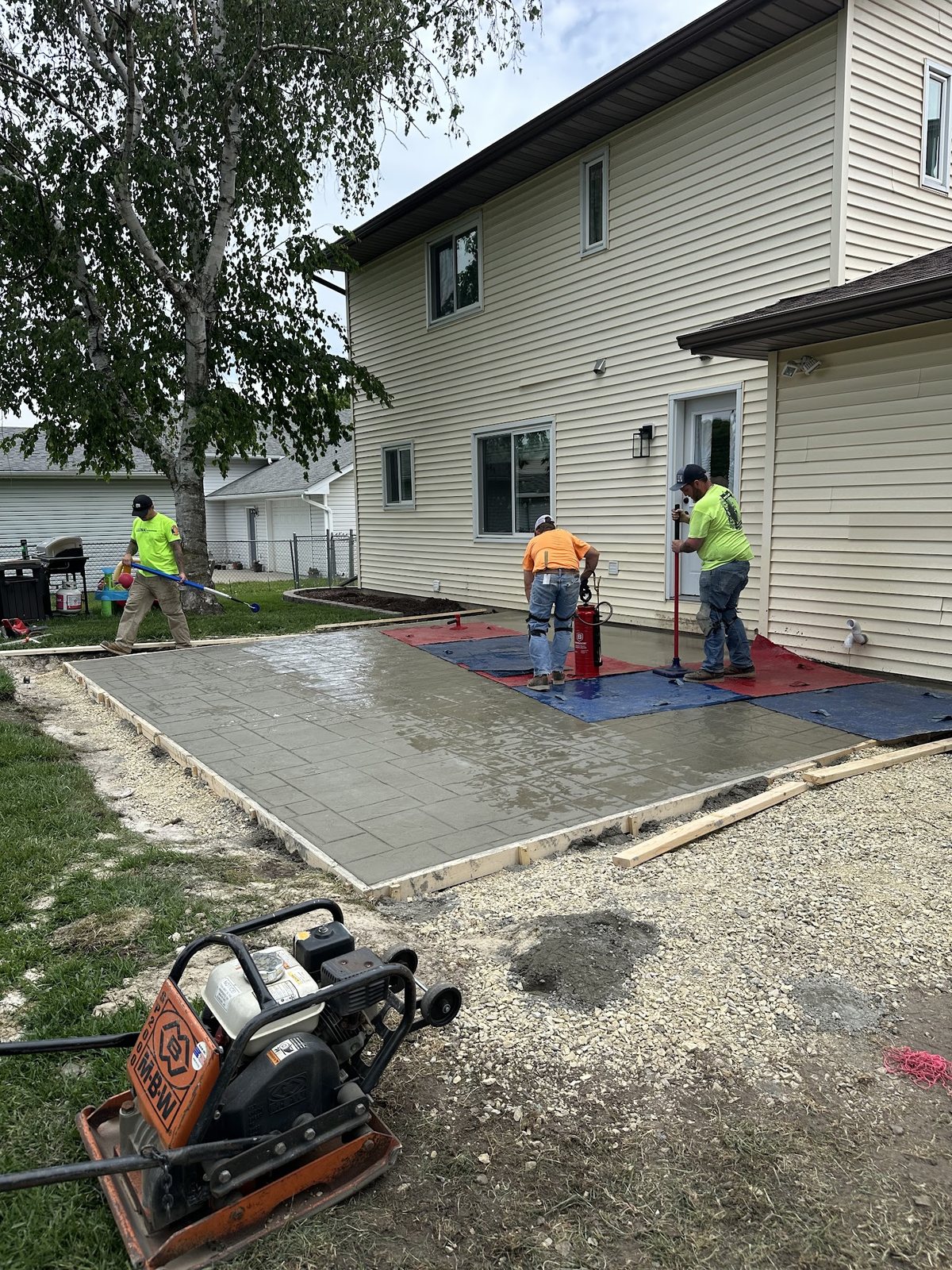 Driftless Craft crew applying a stamped pattern to fresh concrete